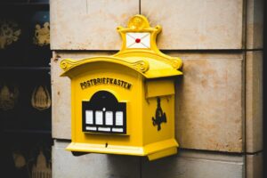 Canada Dropping Bulk‑Stamped Letters into a Blue USPS Collection Box 2026